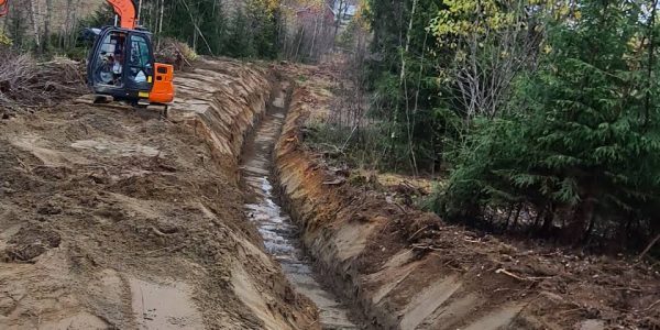 Gravemaskin som graver grøft